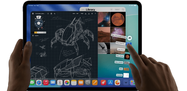iPad Pro, space black color, left hand holding device, right hand pointing gesturing to manipulate multiple open app windows, a drawing app with sketches of mechanical designs, photos library of planets and space images, downloads folder files fanned out