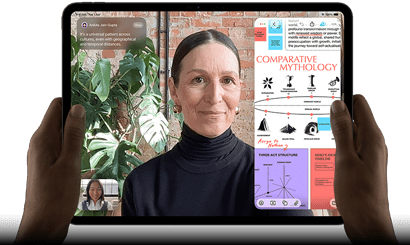 iPad Pro, front exterior, landscape orientation, space black color, rounded corners, black display bezel, hands holding left and right sides, display showing a FaceTime conversation being live translated, and an educational app showing a presentation of "Comparative Mythology" with text, diagrams, and handwritten notes