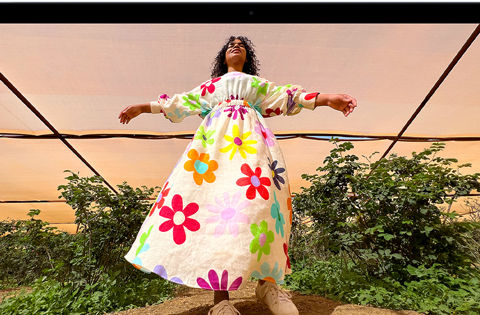 MacBook Air, screen shows an Adobe Photoshop window displaying a photo of a woman in a colorful floral dress, to showcase the brightness of the Liquid Retina display